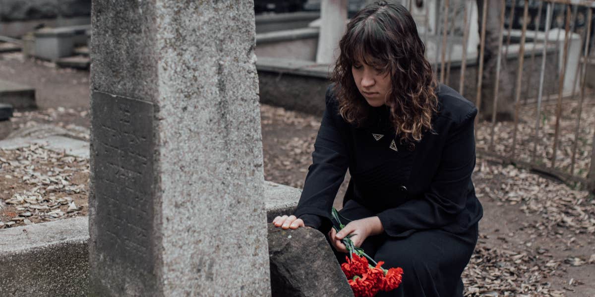 woman with roses at a grave 