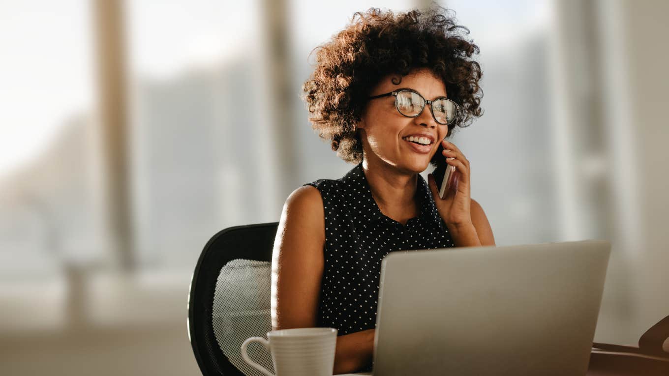 Woman smiling while working from her laptop. 