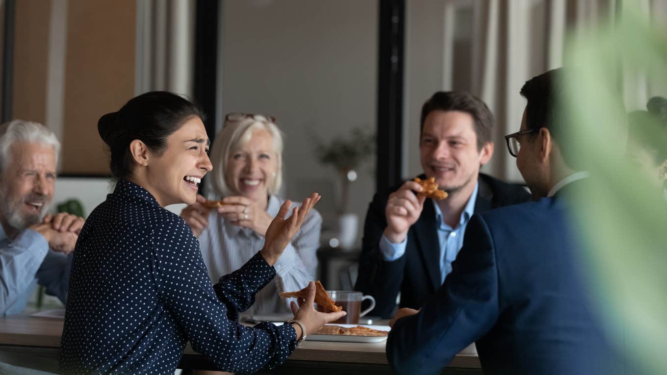 employees eating pizza during break in office together