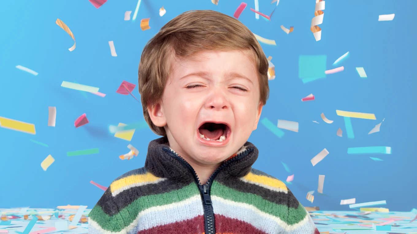 Little boy crying in front of falling birthday confetti