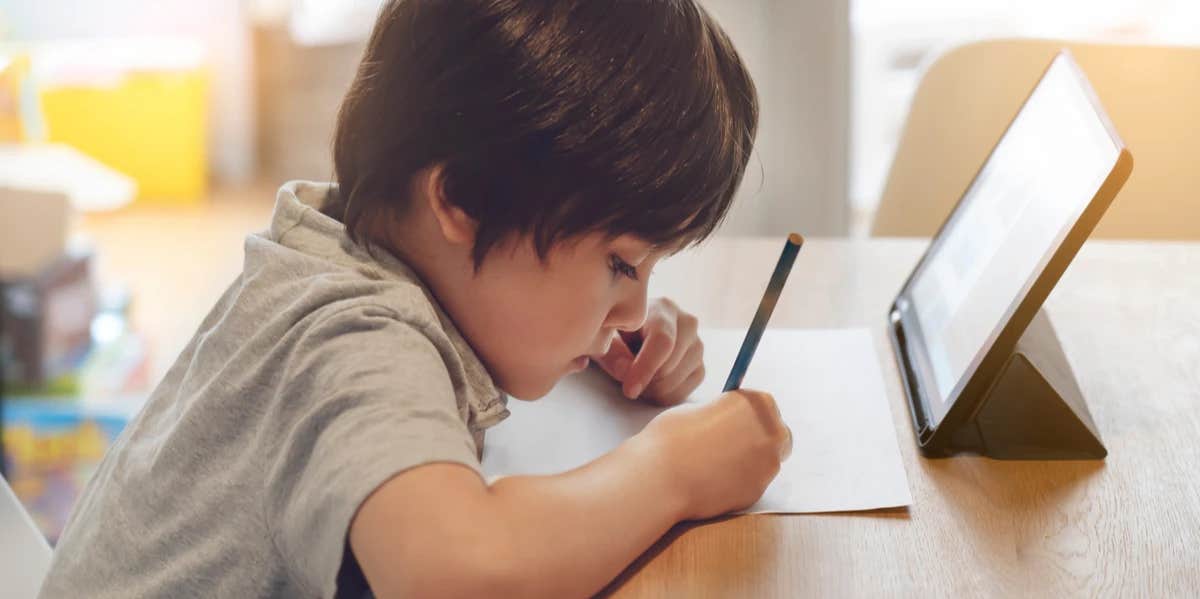 boy writing at a desk