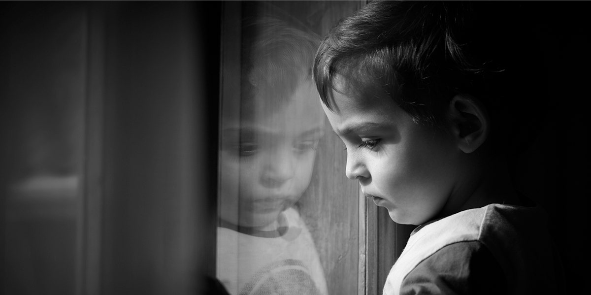 photo of child looking out window in black and white