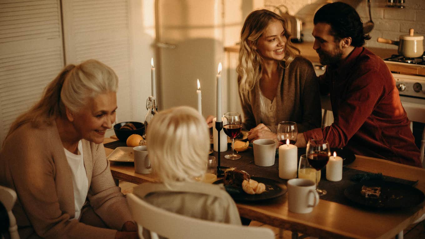 portrait of people sitting around dining table having dinner