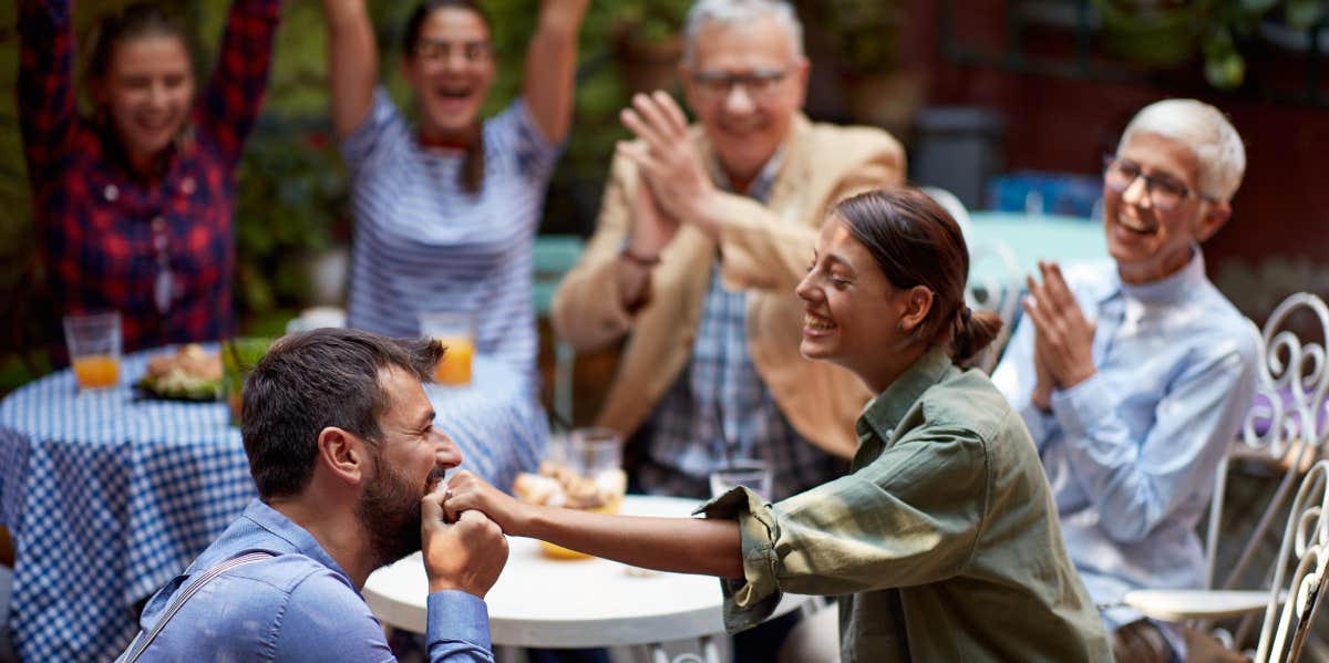 Man proposing to girlfriend in front of family and friends