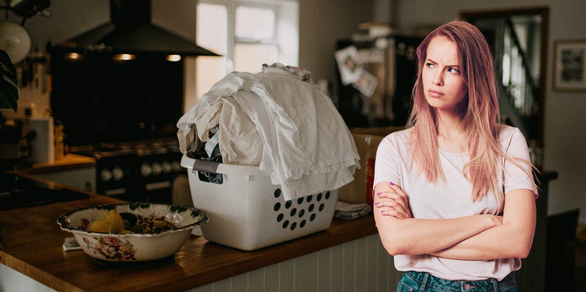 annoyed woman in front of laundry on table