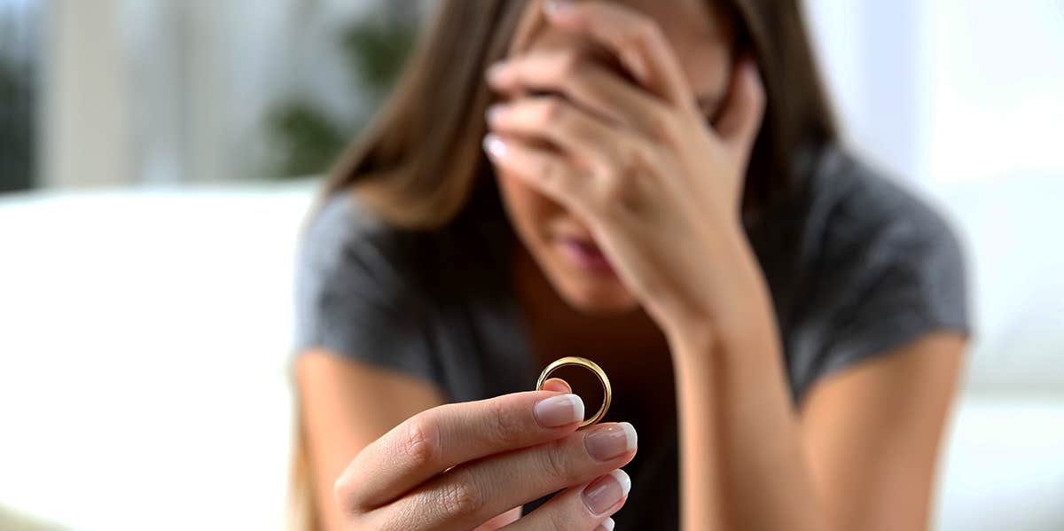 Woman holding ring sadly