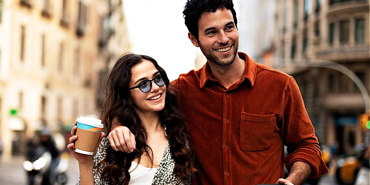 brown-haired man and woman walk down a street