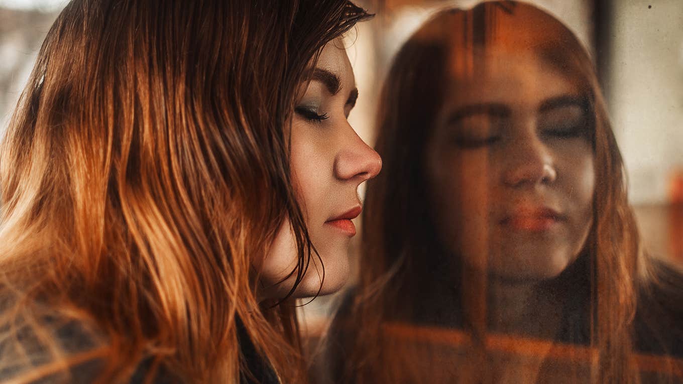 8 Psychological Tricks To Break Up With The Worst Kind Of Narcissist sad woman looks at her reflection in the window
