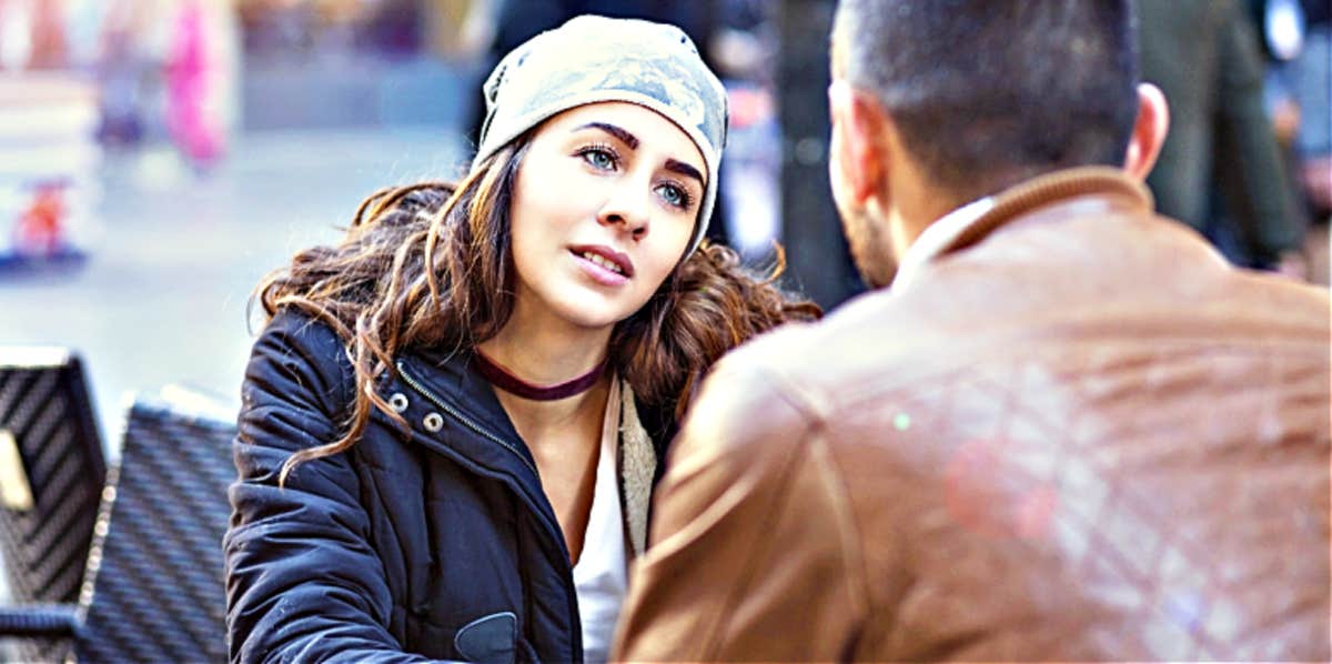 breakup mistakes women make woman looking at man while breaking up in outdoor cafe