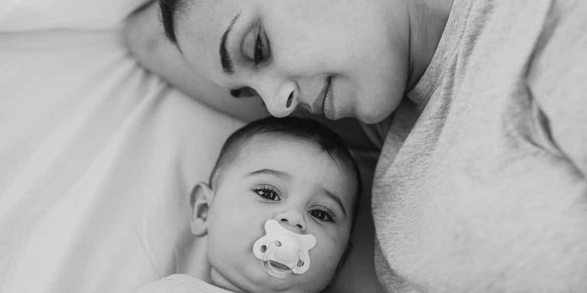 woman laying next to her young baby