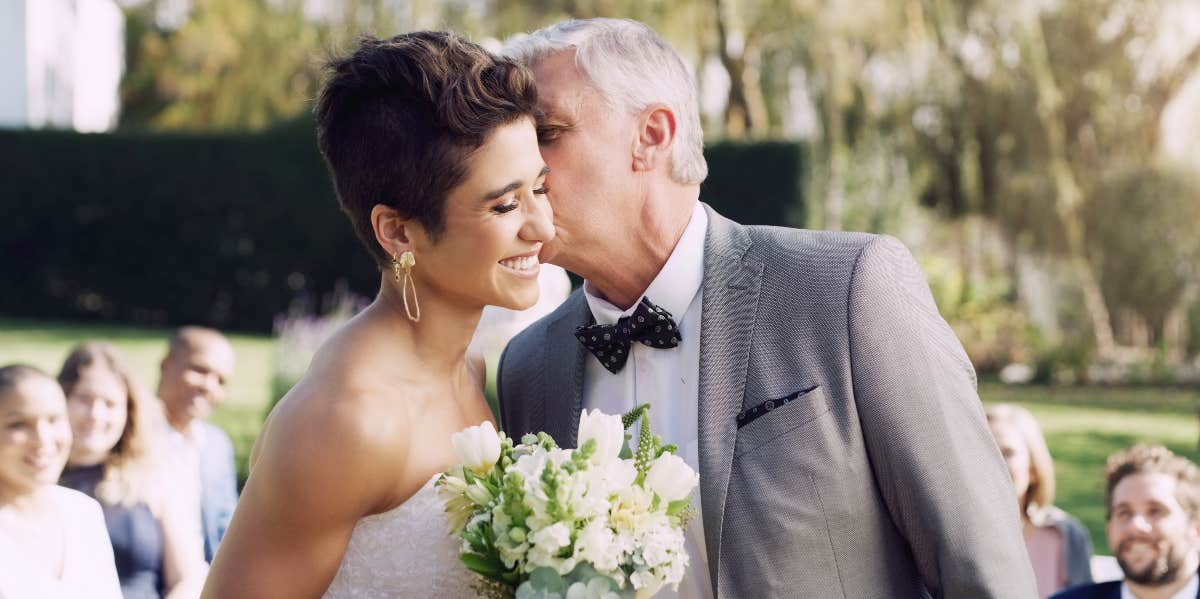 dad kissing bride on cheek at wedding