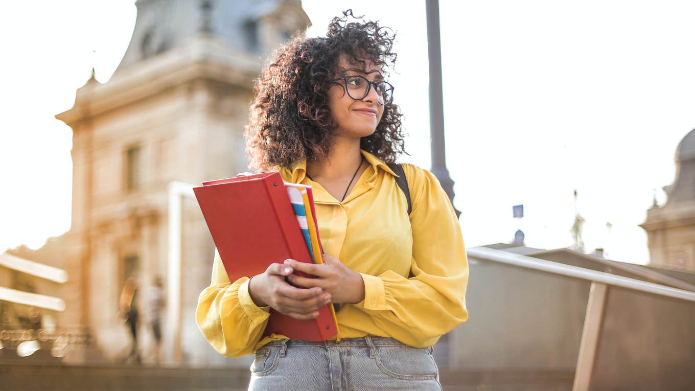 college student on campus holding books 