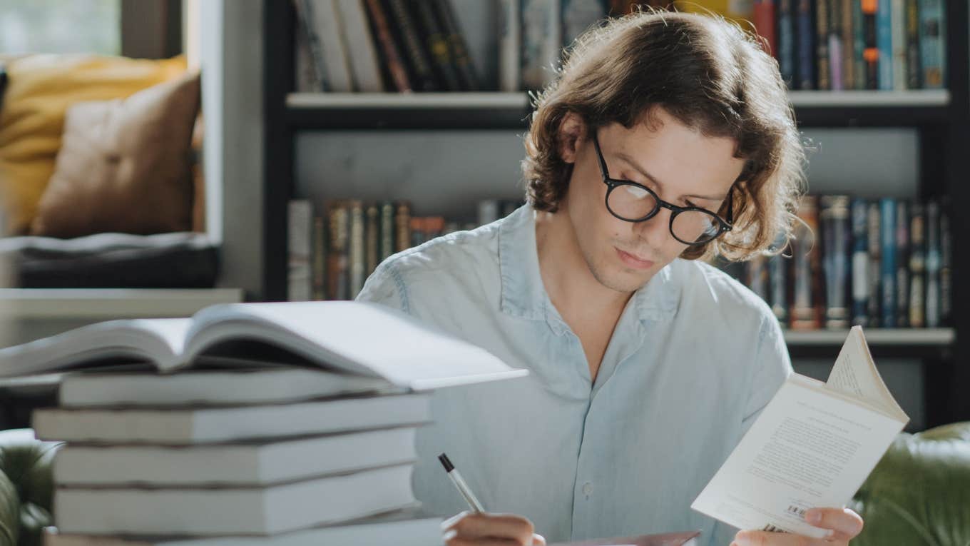 man sitting at a desk reading 