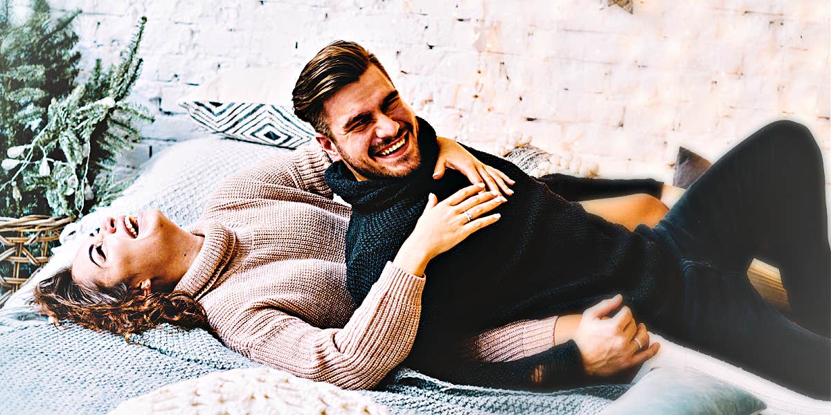 man and woman laughing in bed, wearing sweaters