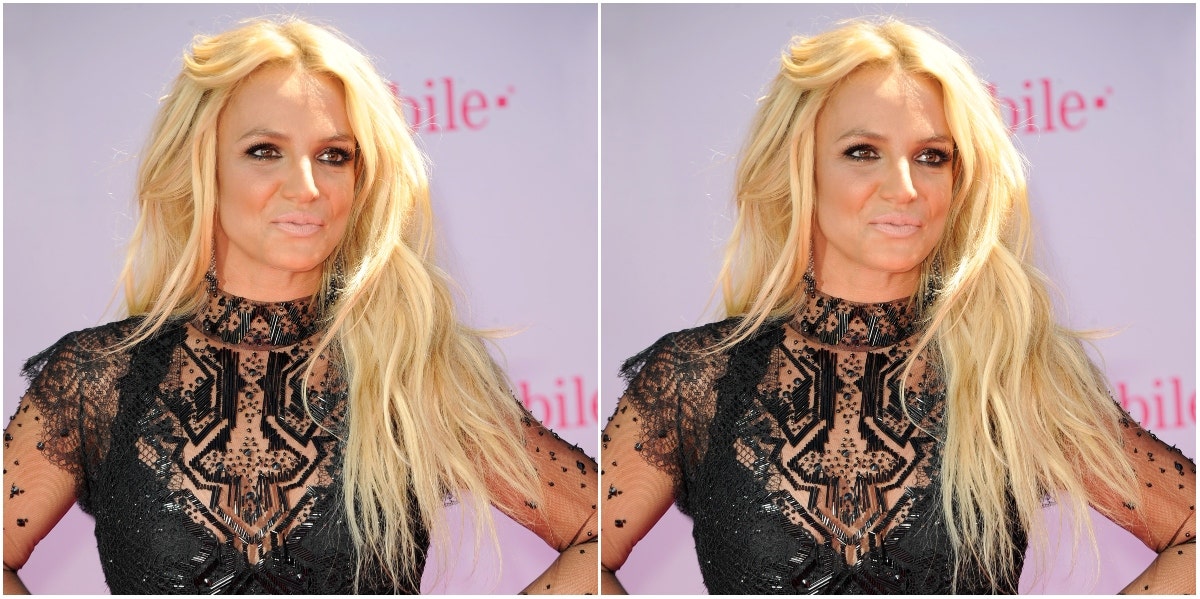 Britney Spears posing in black lace dress on step & repeat