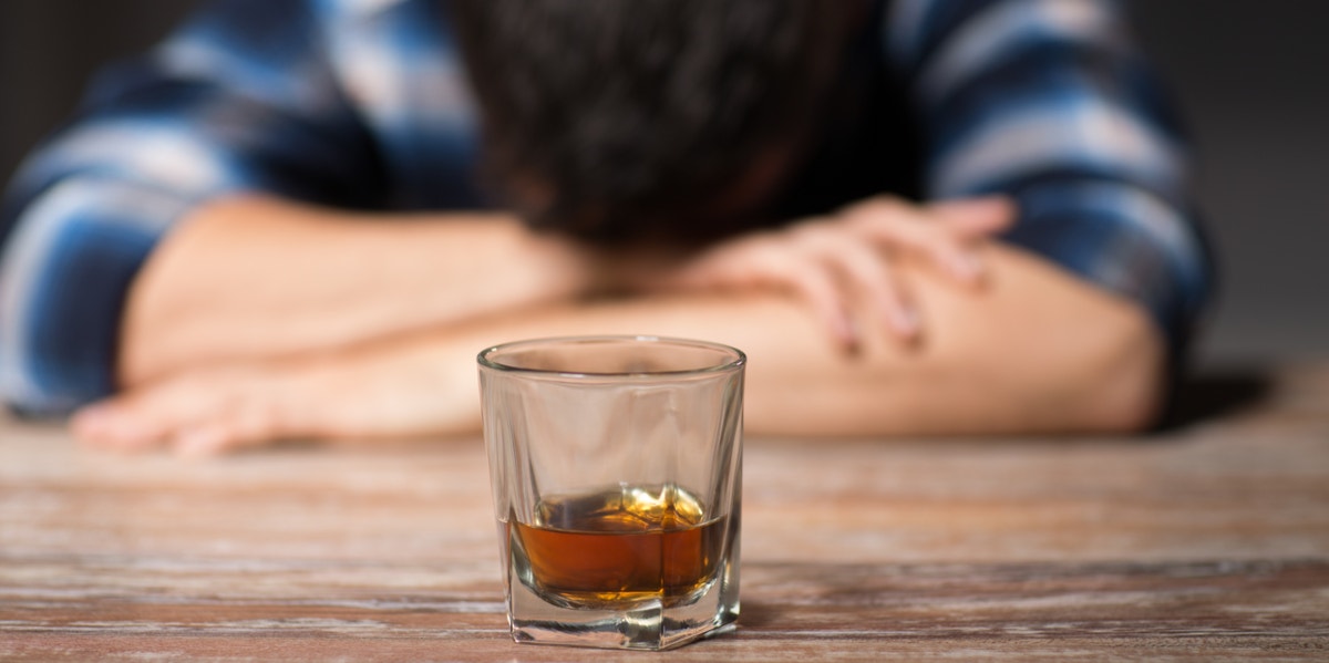 man sitting in front of booze