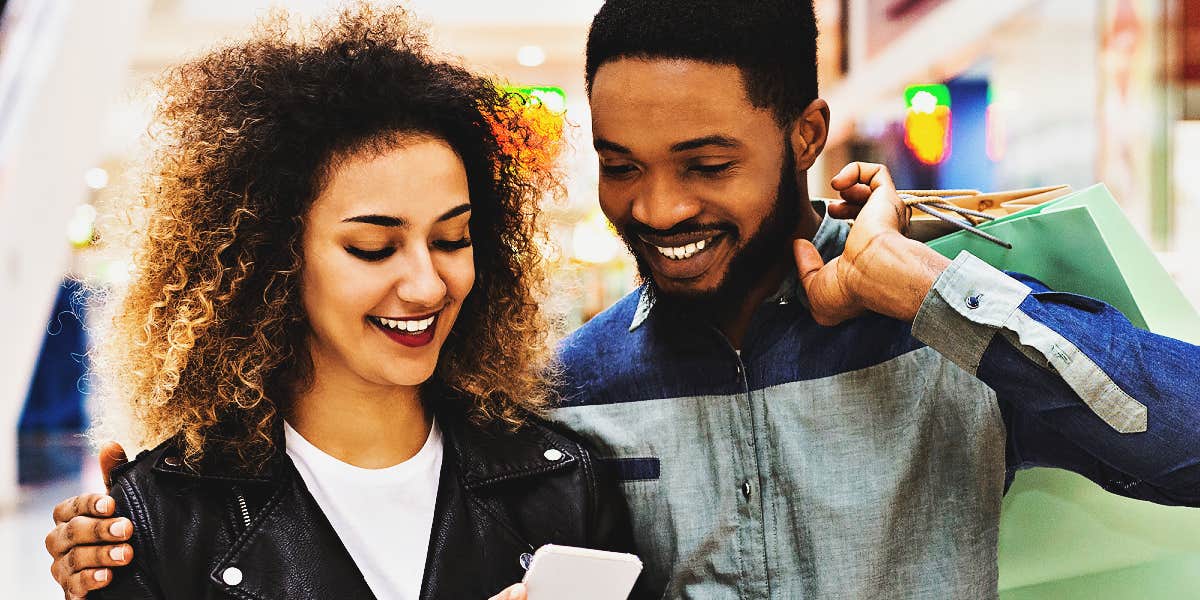 couple shopping, looking at budget on phone