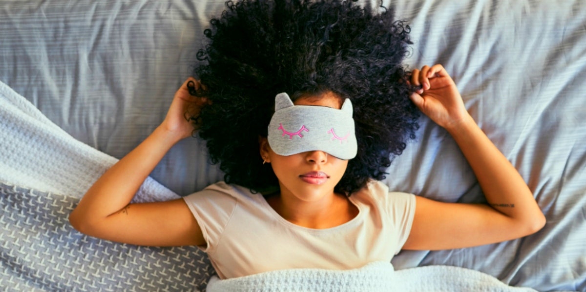 woman lying in bed with eye mask