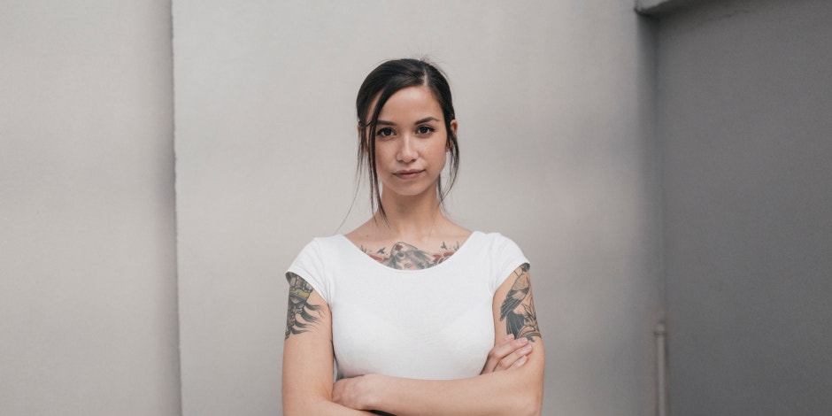 woman standing in white shirt with arms crossed