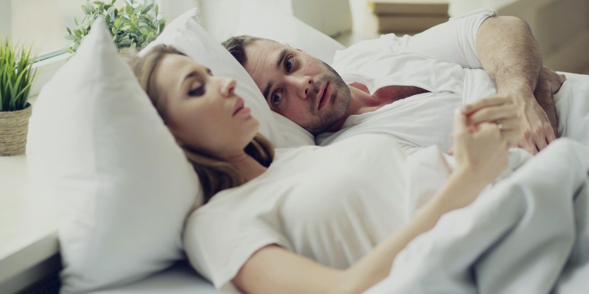 man and woman wearing white in bed