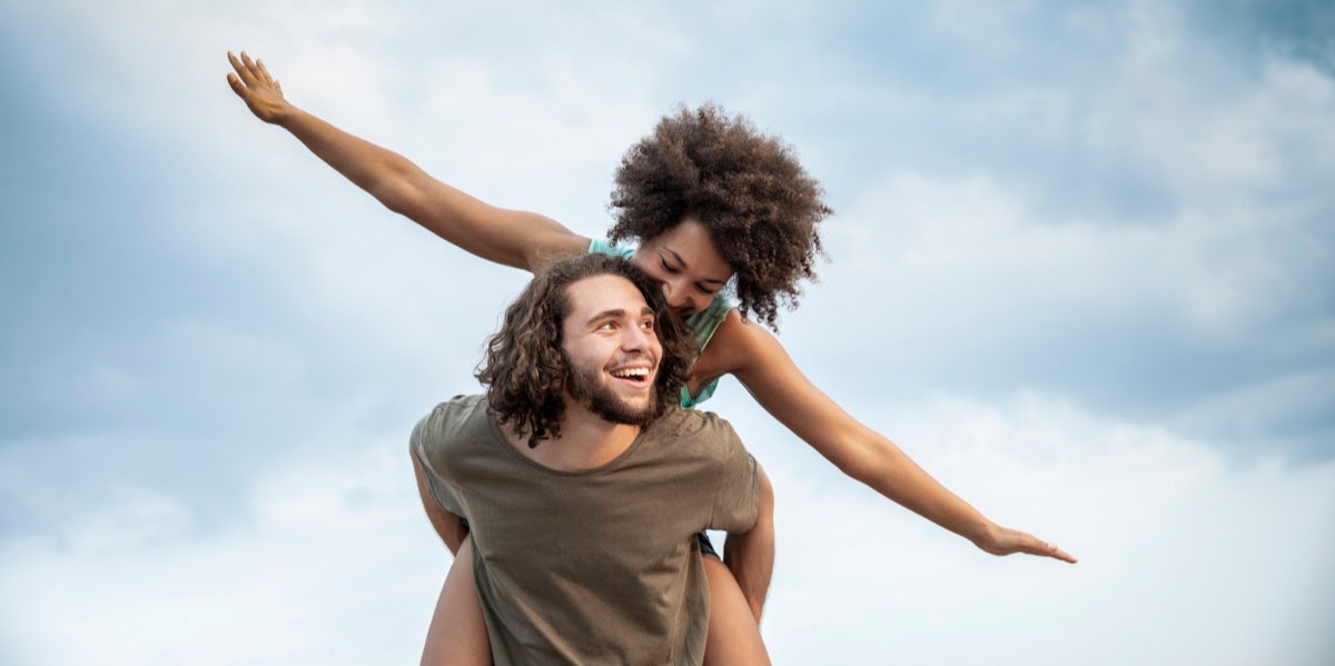 woman getting piggyback ride flying like airplane