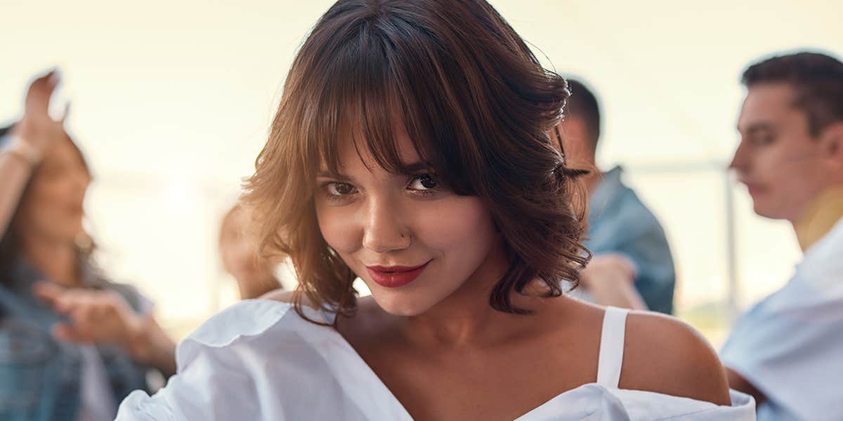 Why Some People Simply Cannot Stop Themselves From Cheating woman with flirtatious grin on face