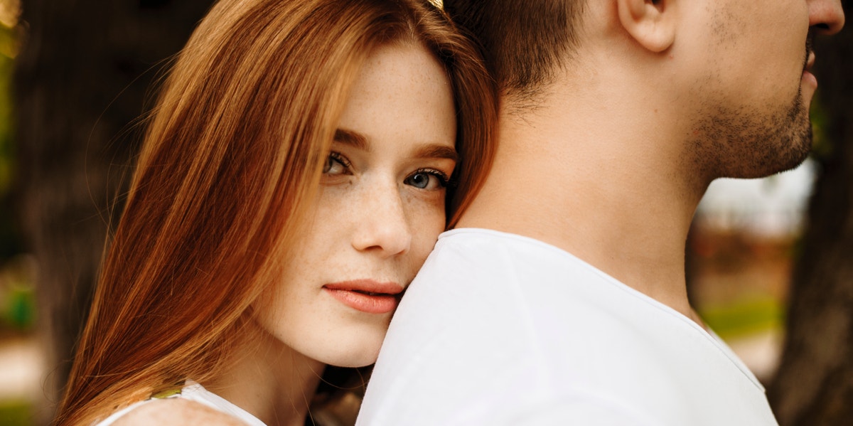 woman leaning on man's back