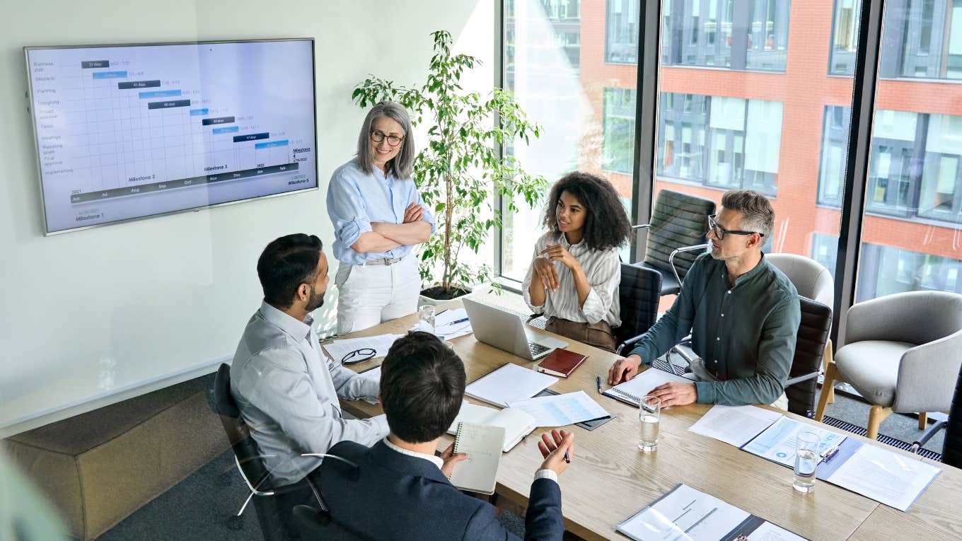 business people discussing company presentation at boardroom table.