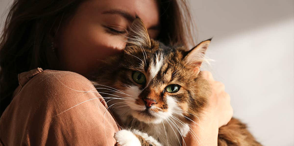 woman hugging cat