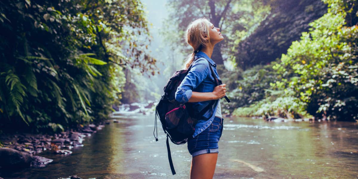 female hiker standing in the forest