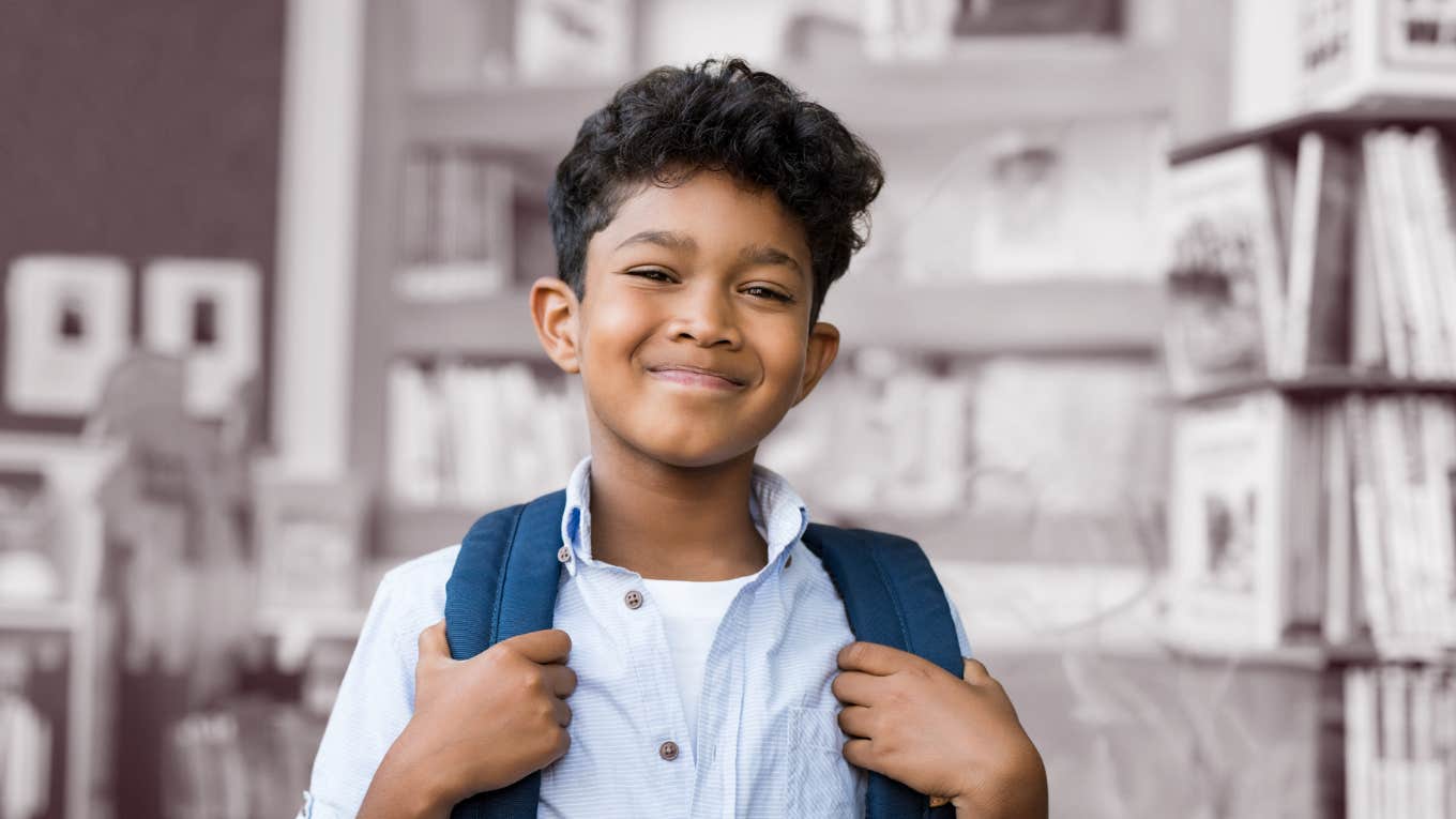 5th grade boy smiling at the camera in a school library