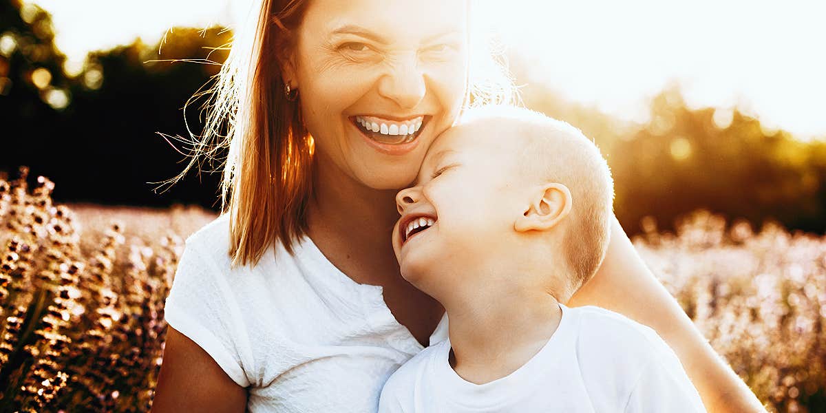 cheating on your spouse is cheating on your family woman smiling in sunset, little boy laughing on her lap