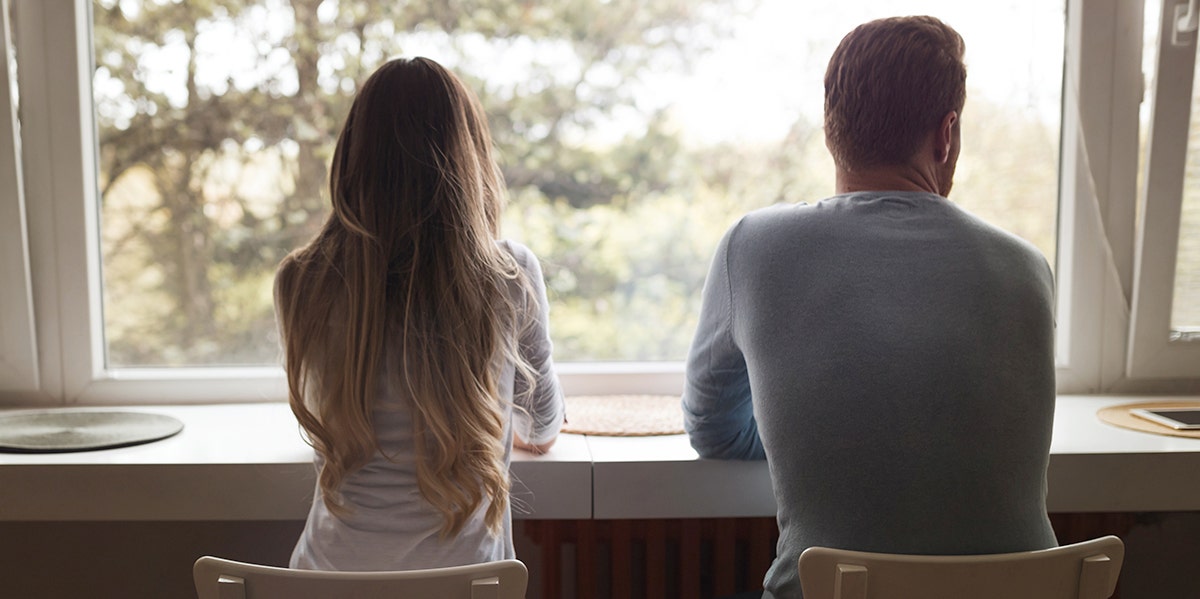 man and woman looking out window