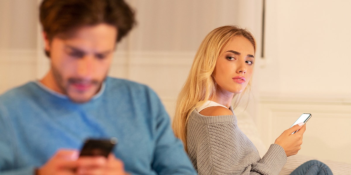 woman on phone looking back at man on phone