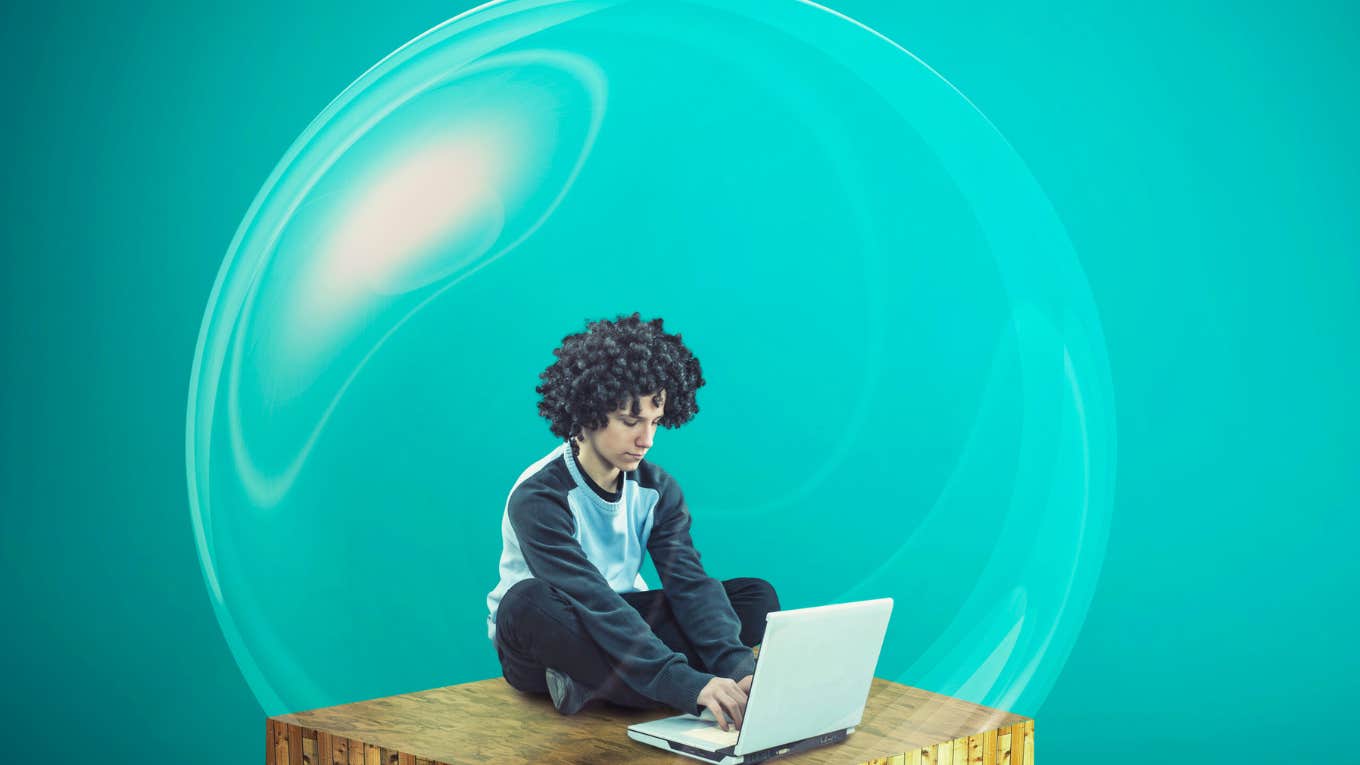 young man on his computer while sitting inside of a bubble