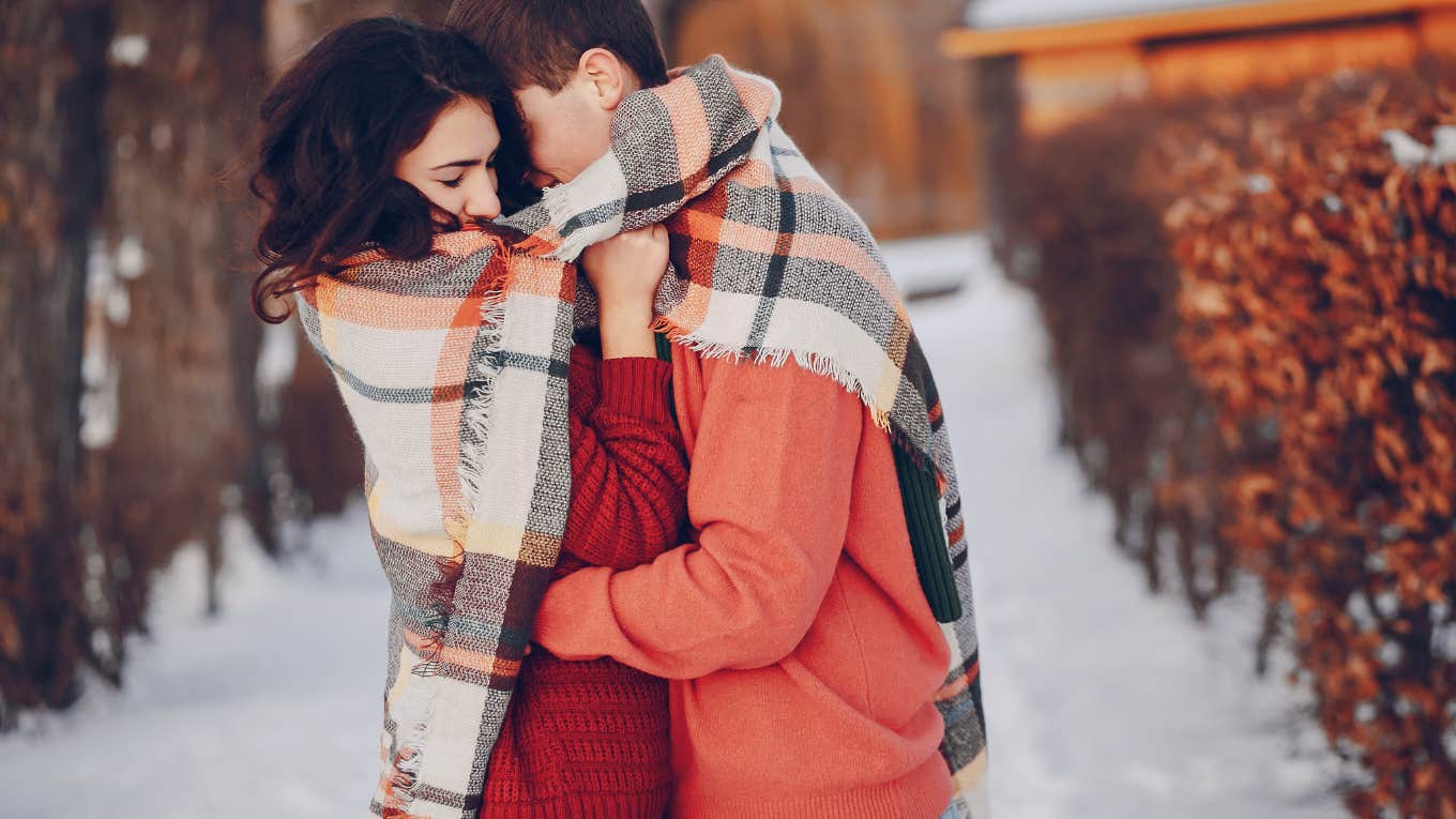 couple snuggling in snow