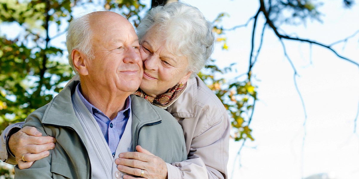 photo of older woman nuzzling older man