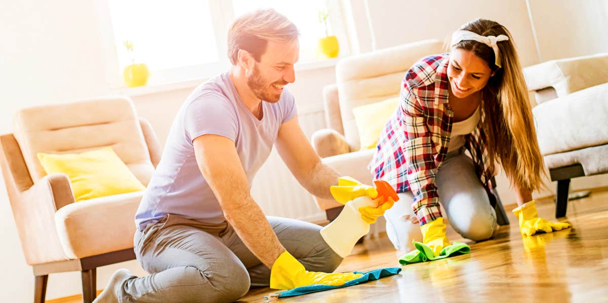 Happy couple clean the floor together