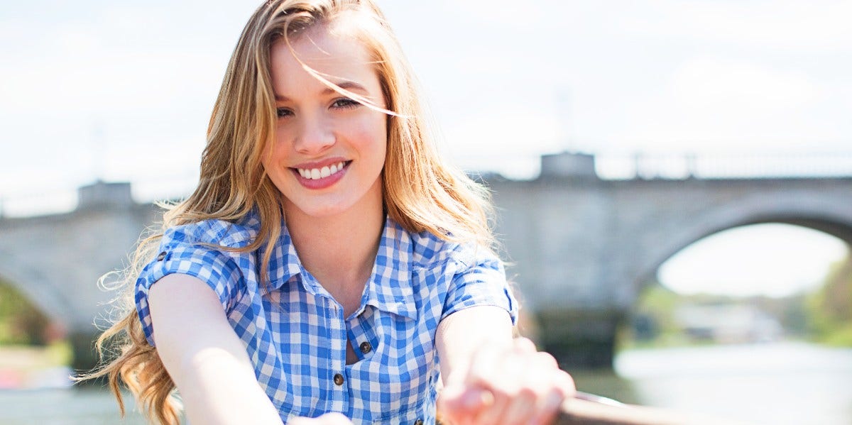 smiling woman by a bridge