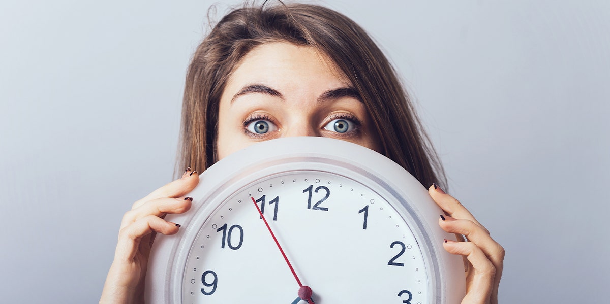 woman holding up clock