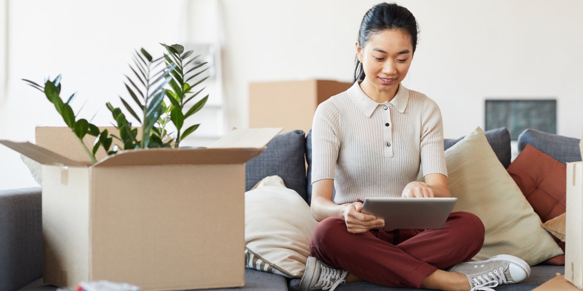 woman sitting with ipad and box with plant