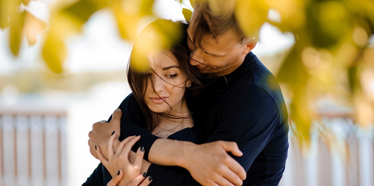 couple hugging in fall leaves