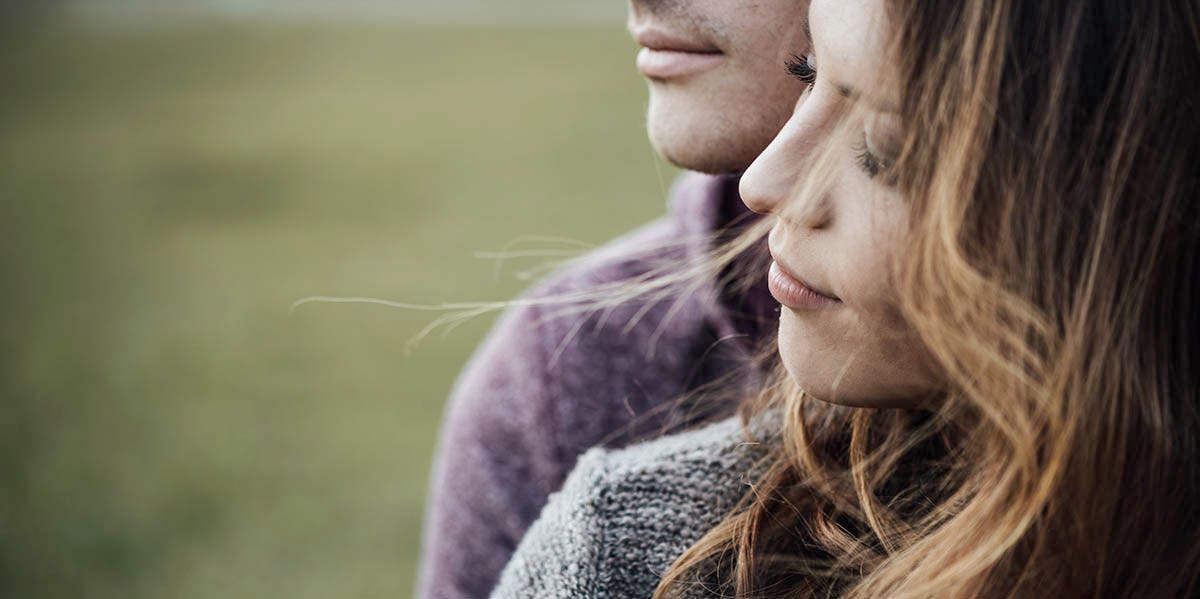 couple gazing together background of grass