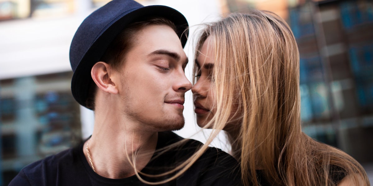couple close to kissing man in top hat
