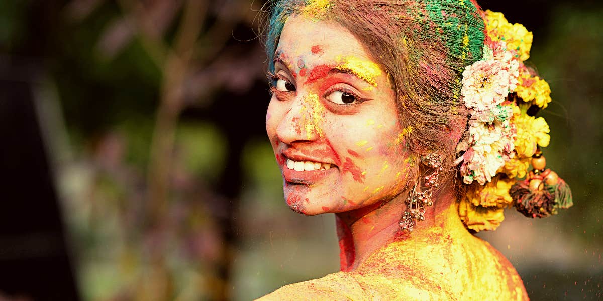 Young woman with multi-color paint on hair and face