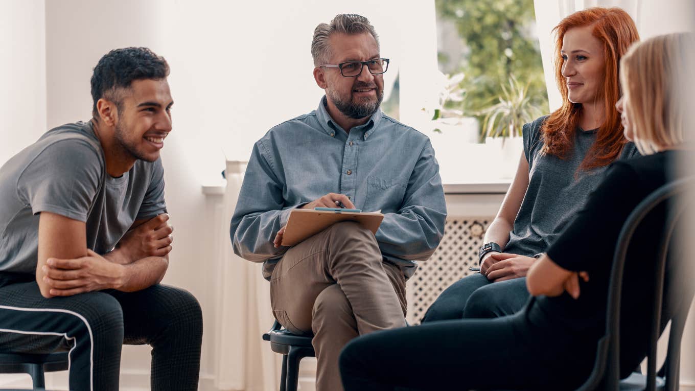 therapist talking to group of people sitting in circle