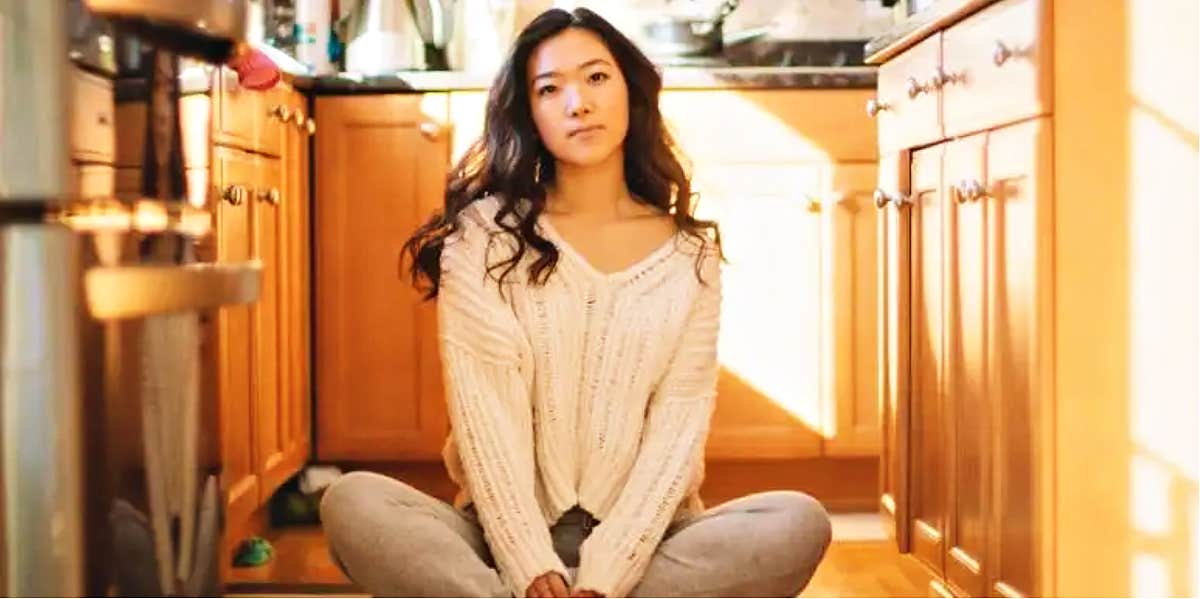 Your body tells you what you need young woman with long dark hair sits on the floor confidently