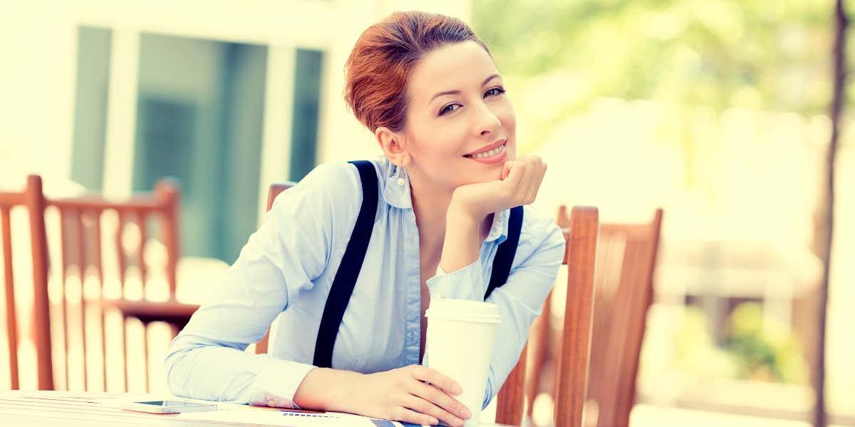 Woman on work break smiles at camera.