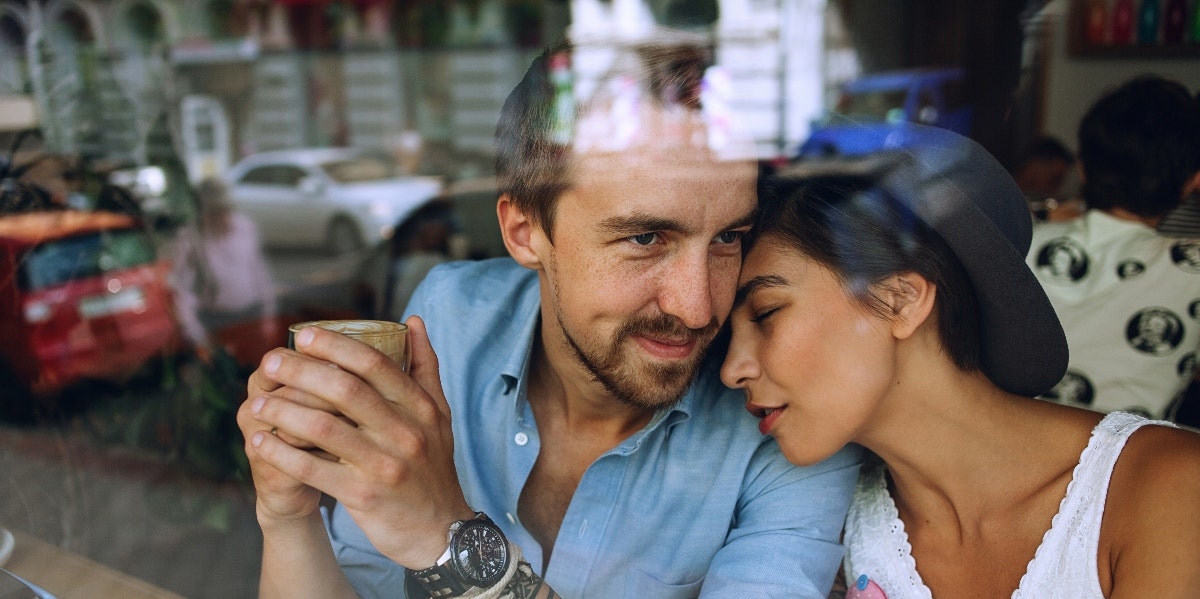 man and woman cuddling in a cafe