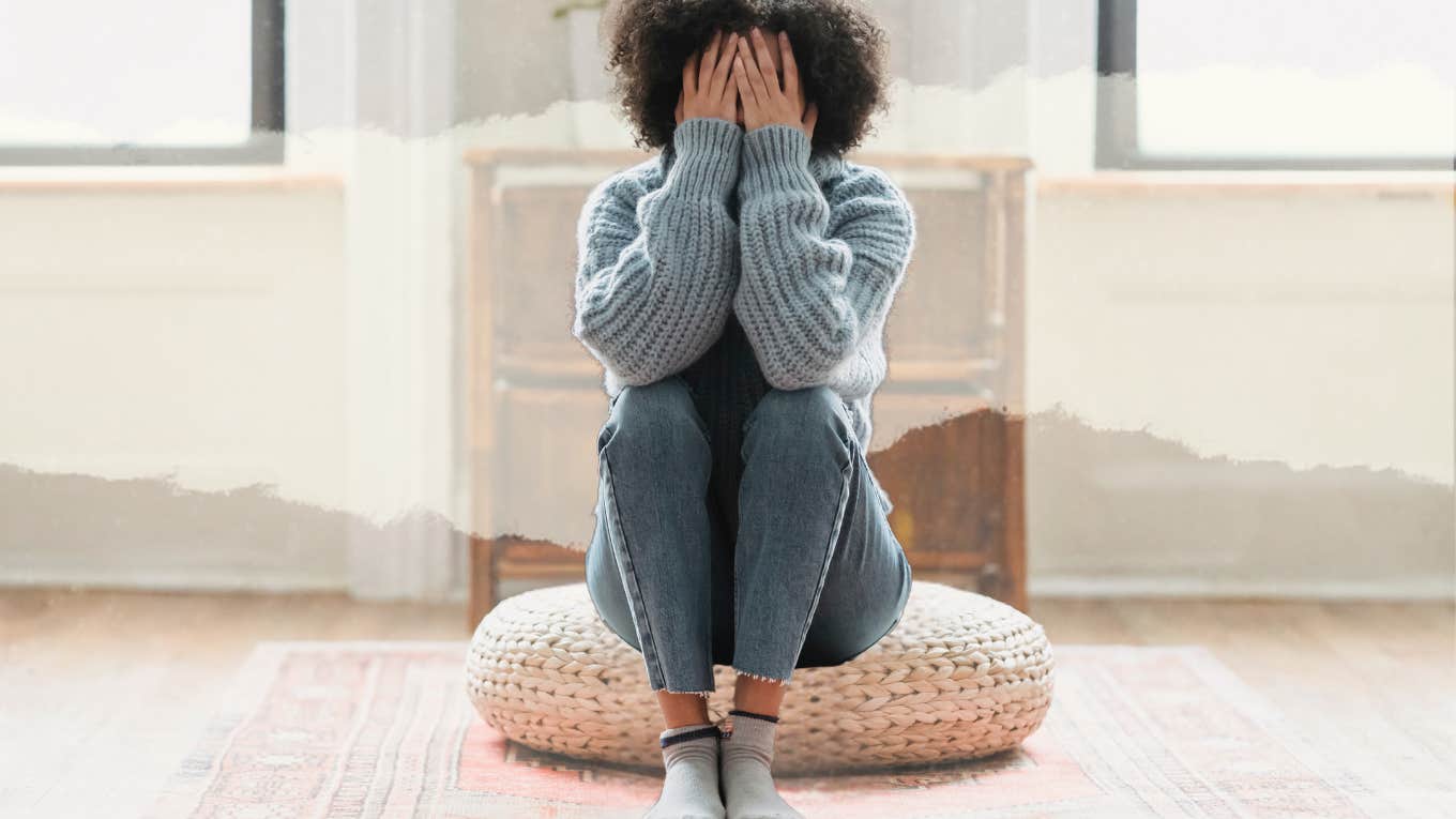 Unhappy woman sitting on pouf in living room